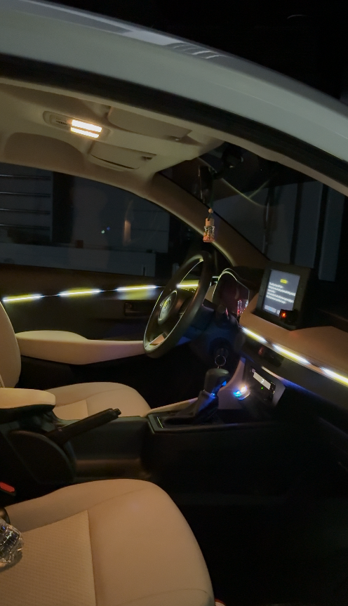 Premium car interior with white LED ambient lighting installed on the dashboard, door panels, and centre console for a luxury driving experience.