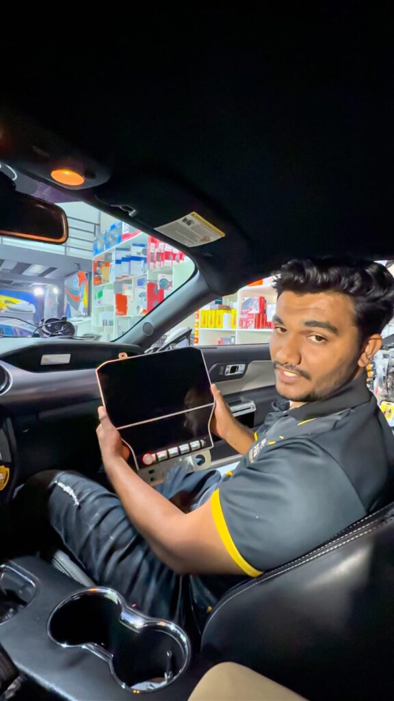 Technician showing an Android screen before professional installation in a car in Dubai.