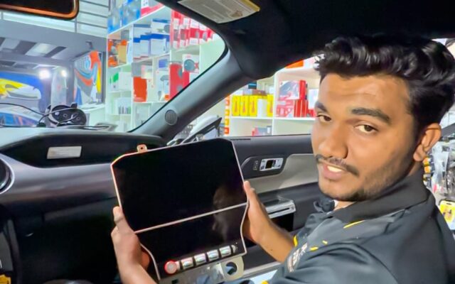 Technician showing an Android screen before professional installation in a car in Dubai.