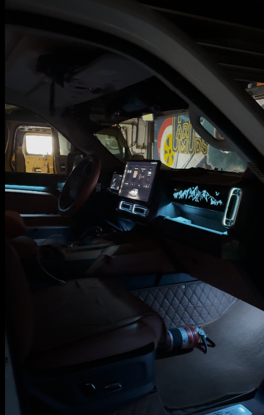 Modern SUV interior with cool white LED ambient lighting on the dashboard, door panels, air vents, and footwell, creating a clean and premium cabin atmosphere.
